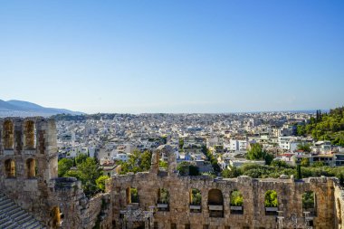 Lowrise beyaz binalar mimari, dağ, ağaçlar ve açık mavi gökyüzü arka plan görmek antik taş tiyatro ile Atina cityscape bakış