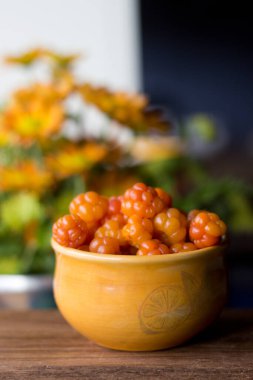 Cloudberry Rubus chamaemorus, ahşap masa üzerinde turuncu kâseye, Norveç 'te sonbahar hasadı Hemsedal kayak merkezi yakınlarında Buskerud, Norveç' te, takvim, poster, duvar kağıdı basmak için fotoğraf