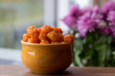 Cloudberry Rubus chamaemorus, ahşap masa üzerinde turuncu kâseye, Norveç 'te sonbahar hasadı Hemsedal kayak merkezi yakınlarında Buskerud, Norveç' te, takvim, poster, duvar kağıdı basmak için fotoğraf