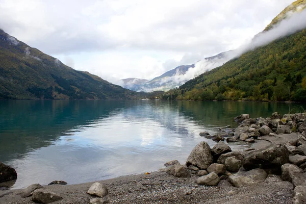 Prachtig Noors landschap in de herfst nabij Loen en Stryn in Noorwegen, Lovatnet in oktober, Noorse natuur, outdoor schoonheid, meer met turquoise water en lage wolken boven in de ochtend — Stockfoto