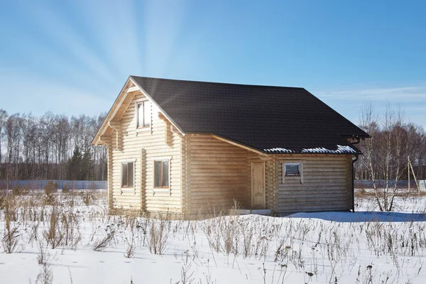 Maison en bois en hiver, reflet des rayons du soleil dans une fenêtre — Photo