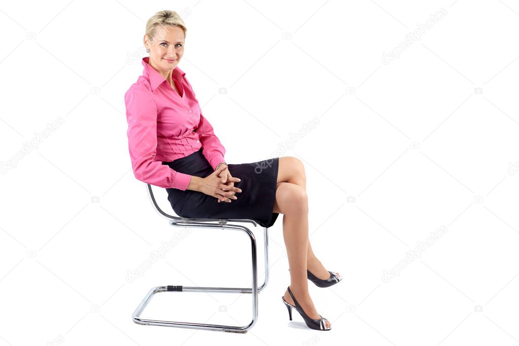 Successful businesswoman sitting sideways on a chair, isolated on white background