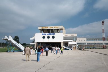 Pula, Hırvatistan - 29 Ağustos 2007: Pula kenti Havalimanı (Istria bölgesi, Adriyatik kıyısı), terminale giden yolcular.