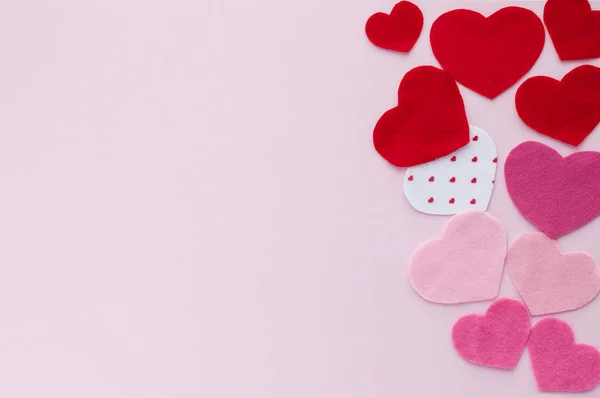 Tarjeta horizontal San Valentín. Corazones rojos y rosados de diferentes tamaños sobre un fondo rosa claro con espacio para copiar . — Foto de Stock
