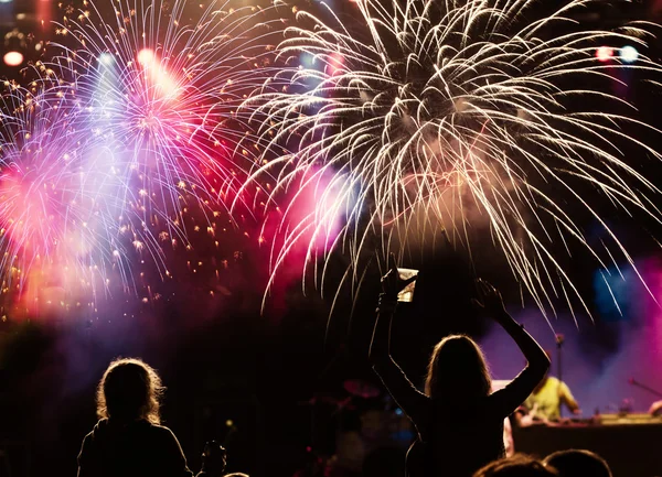 Nieuwjaarsconcept - juichende menigte en vuurwerk — Stockfoto