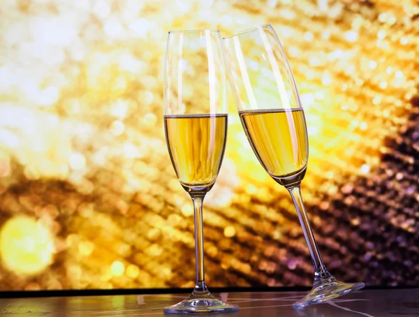 Toasting with champagne glasses against holiday lights — Stock Photo, Image