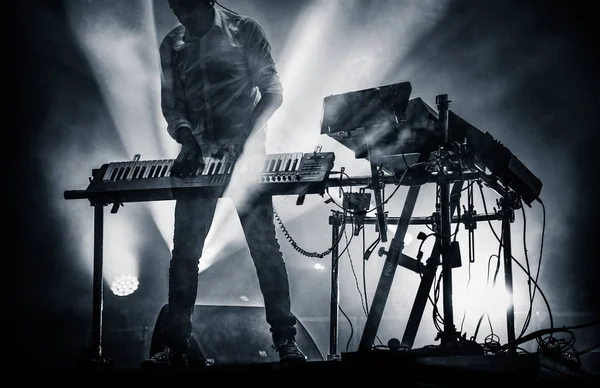 Disc jokey mixing on stage over illuminated smoke background - s — Stock Photo, Image