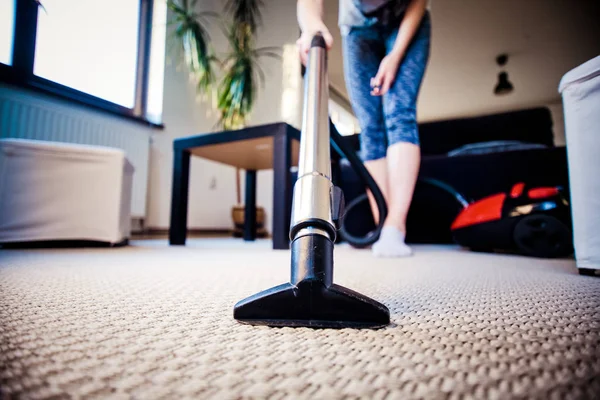 Wanita membersihkan karpet dengan vacuum cleaner di kamar-fokus pada h — Stok Foto