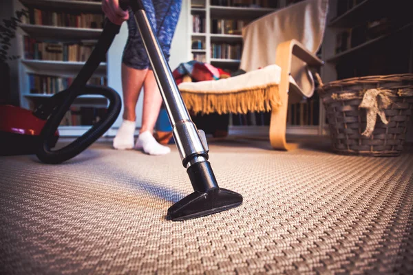 清洗地毯用吸尘器在房间里-专注于 h 的女人 — 图库照片