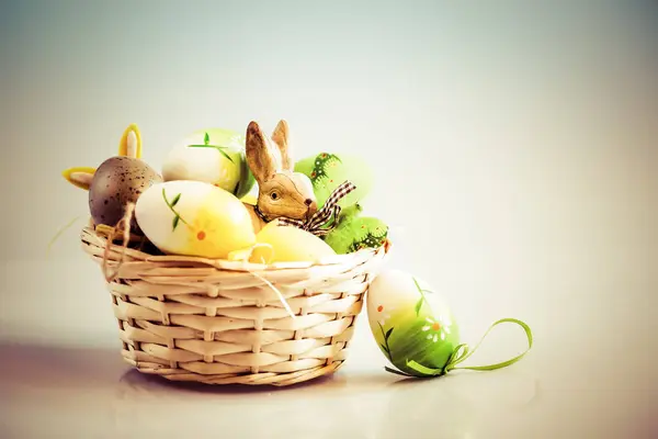 Huevos de Pascua y conejito en cesta — Foto de Stock