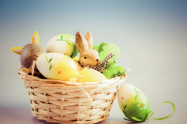 Huevos de Pascua y conejito en cesta — Foto de Stock