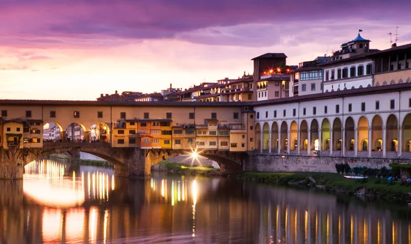 Zonsondergang boven de Ponte Vecchio - oude brug uitzicht vanaf de oever van de Arno — Stockfoto