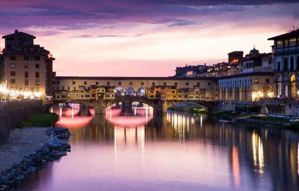 Zonsondergang boven de Ponte Vecchio - oude brug uitzicht vanaf de oever van de Arno — Stockfoto