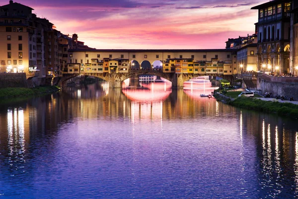 Zonsondergang boven de Ponte Vecchio - oude brug uitzicht vanaf de oever van de Arno — Stockfoto