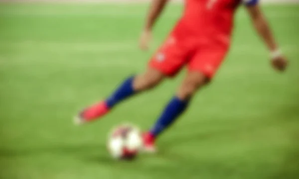 Футболист пинает мяч - размытый фон — стоковое фото