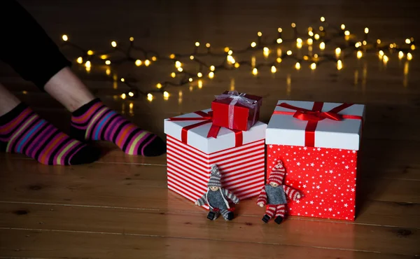 Czerwony prezent pola stopy i Boże Narodzenie światła na drewnianej podłodze — Zdjęcie stockowe