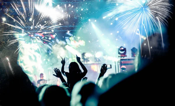 Crowd with raised hands watching fireworks - New Year concept — Stock Photo, Image