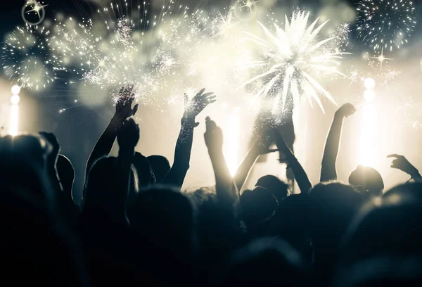 Crowd with raised hands watching fireworks - New Year concept — Stock Photo, Image