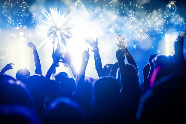 Menschenmenge mit erhobenen Händen beobachtet Feuerwerk - Neujahrskonzept — Stockfoto