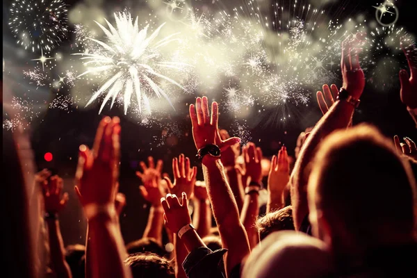 Crowd with raised hands watching fireworks - New Year concept — Stock Photo, Image