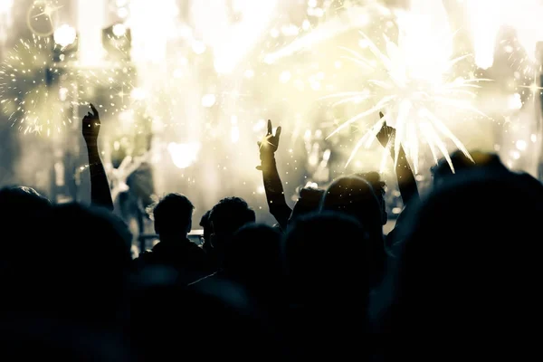 Crowd with raised hands watching fireworks - New Year concept — Stock Photo, Image