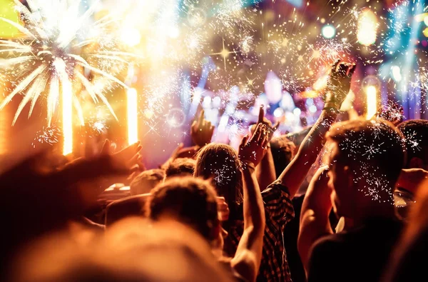 Multitud con las manos levantadas viendo fuegos artificiales - Concepto de Año Nuevo — Foto de Stock