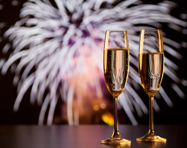 Dos copas de champán contra luces navideñas y fuegos artificiales - nuevo — Foto de Stock