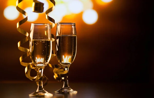 Twee champagneglazen met linten tegen vakantie lichten en fi — Stockfoto