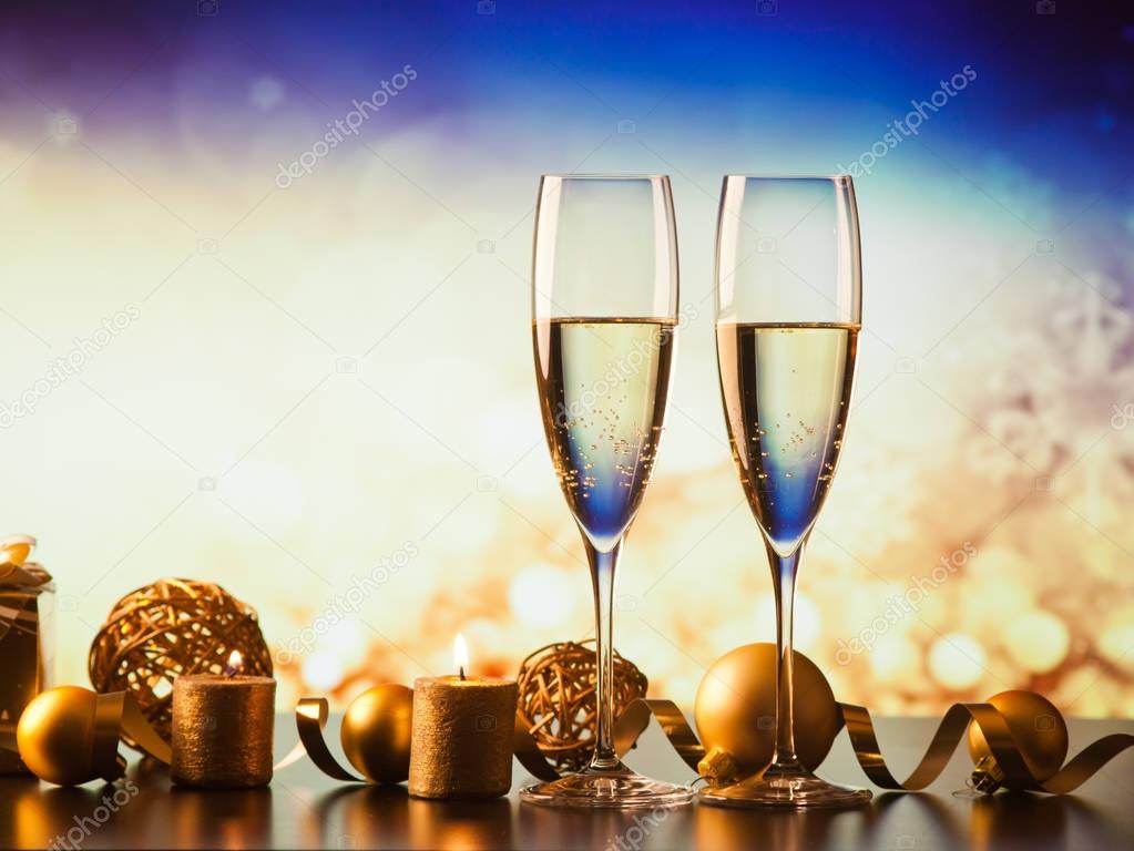 two champagne glasses against holiday lights and fireworks - new