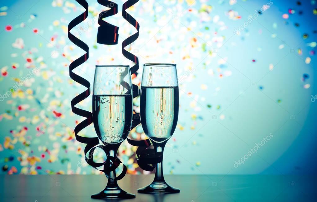 two champagne glasses with ribbons and falling confetti - New Ye