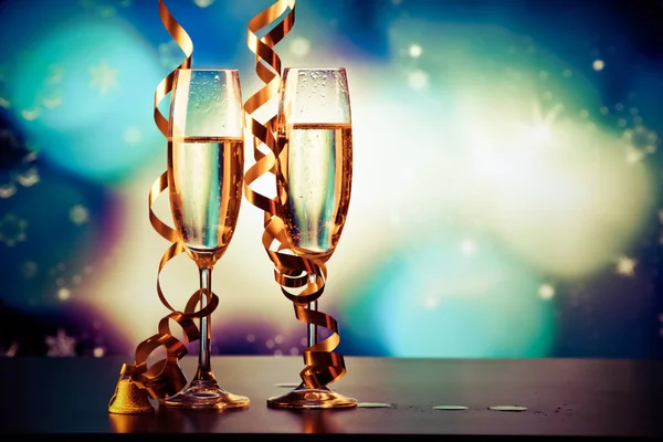 Dois copos de champanhe com fitas contra luzes de férias e fi — Fotografia de Stock
