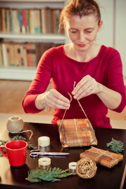 Noel hediyelerini paketleyen kadın.