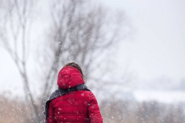 kadın kırmızı paltolu kırsal kesimde yoğun kar yağışı yürüyüş