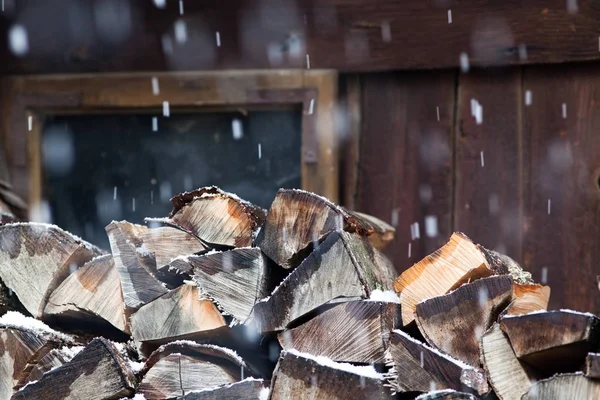 Troncos de árboles cerca del cobertizo en nevadas listos para la calefacción de invierno — Foto de Stock