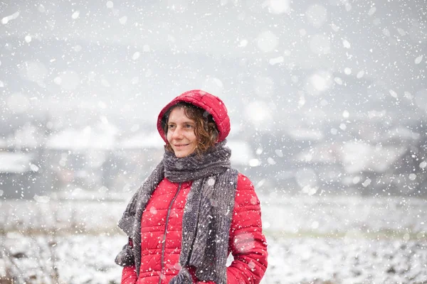 Femeie în haină roșie mergând în zăpadă grea în mediul rural — Fotografie, imagine de stoc