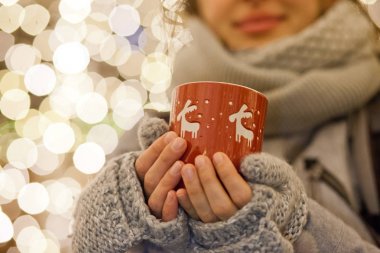 Kupa mulled şarap ile Noel markette tutan kadın