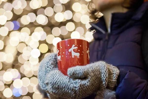 Mulher segurando caneca com vinho quente no mercado de natal — Fotografia de Stock