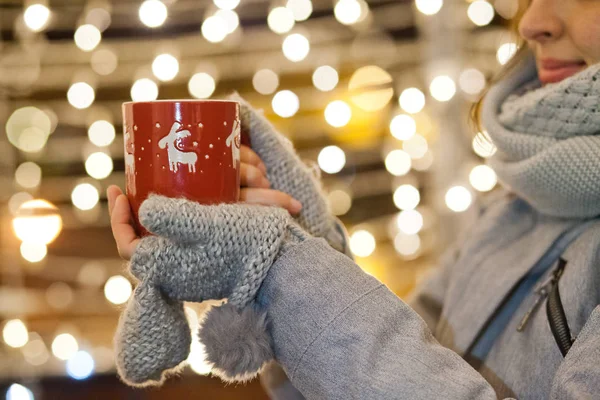 Kvinna som håller mugg med glögg på julmarknad — Stockfoto