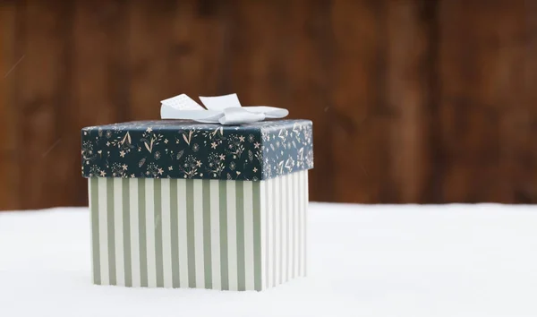 Gift box in snow - christmas lights — Stock Photo, Image