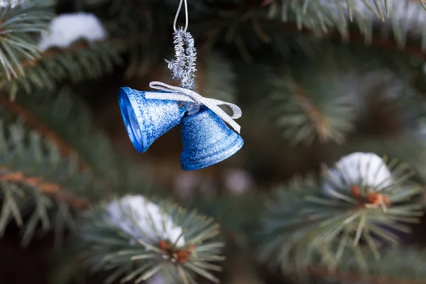 Niebieskie Dzwonki Świąteczne dekoracje wiszące na ośnieżone drzewa — Zdjęcie stockowe