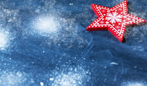 Rode kerstversiering op blauw met sneeuw — Stockfoto