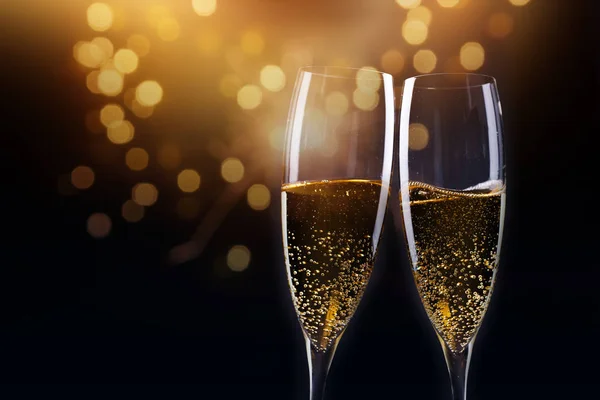 Brinde com taças de champanhe contra luzes de férias e novo y — Fotografia de Stock