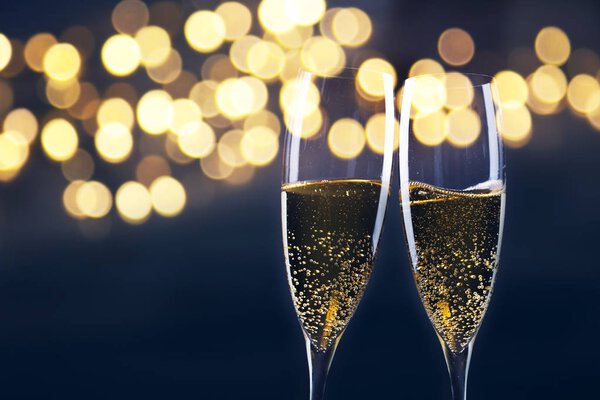 toasting with champagne glasses against holiday lights and new y