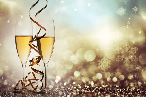 Two champagne glasses with ribbons against holiday lights and fi — Stock Photo, Image