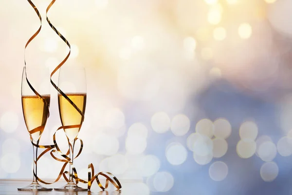 Dos copas de champán con cintas contra luces navideñas y fi —  Fotos de Stock