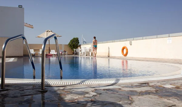 Mujer cerca de piscina en la azotea en Dubai — Foto de Stock