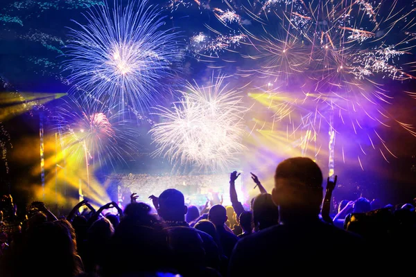 Crowd celebrating New Year with fireworks — Stock Photo, Image