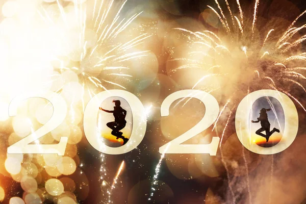 fireworks and 2020 background for new year silhouette jumping in