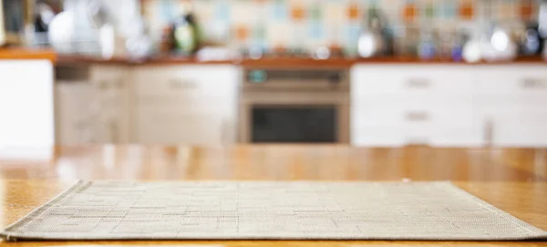 Blurred kitchen interior with napkin on table — Stock Photo, Image
