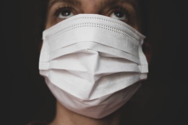  Bir kadın ağzına ve burnuna kağıt bir maske takar.